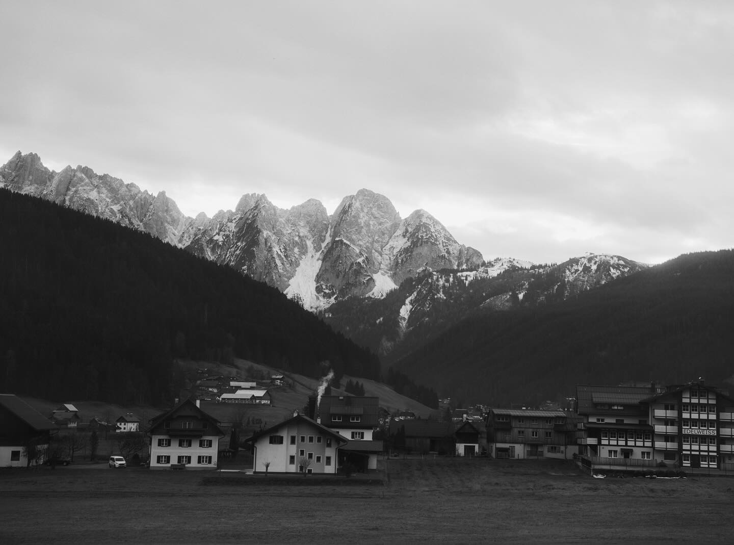 Hallstatt mirrored in the lake with ochre forest on the mountain